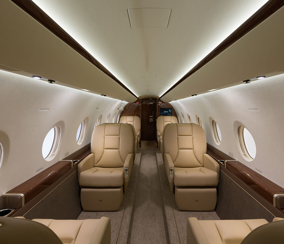 Luxurious interior of a Gulfstream G280 business jet with leather seating and modern cabin lighting, highlighting comfort and speed.